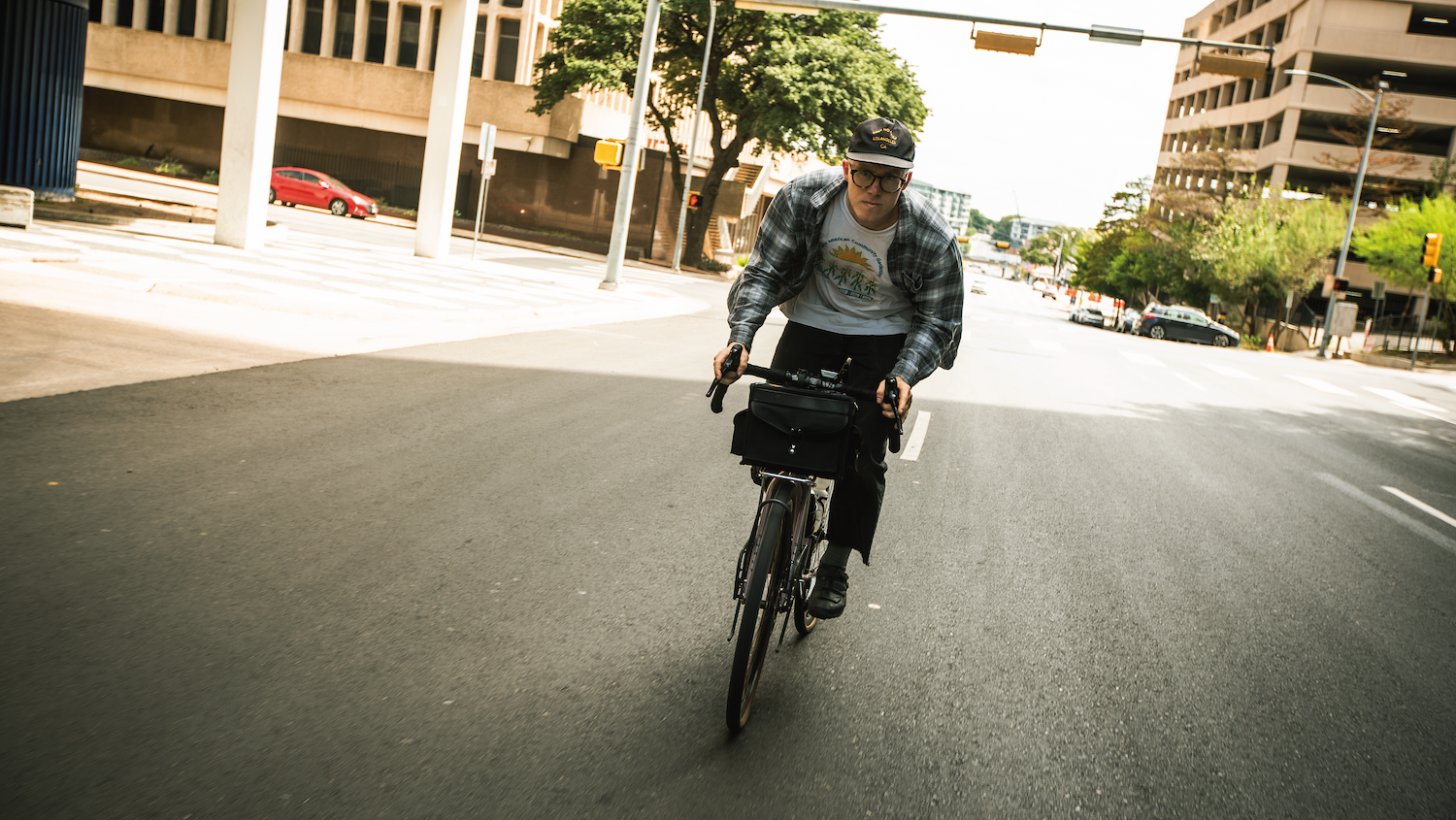 biker riding down a city street wearing a yellow fattypack